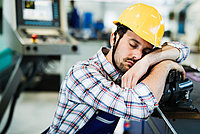 Mann schläft erschöpft bei der Arbeit