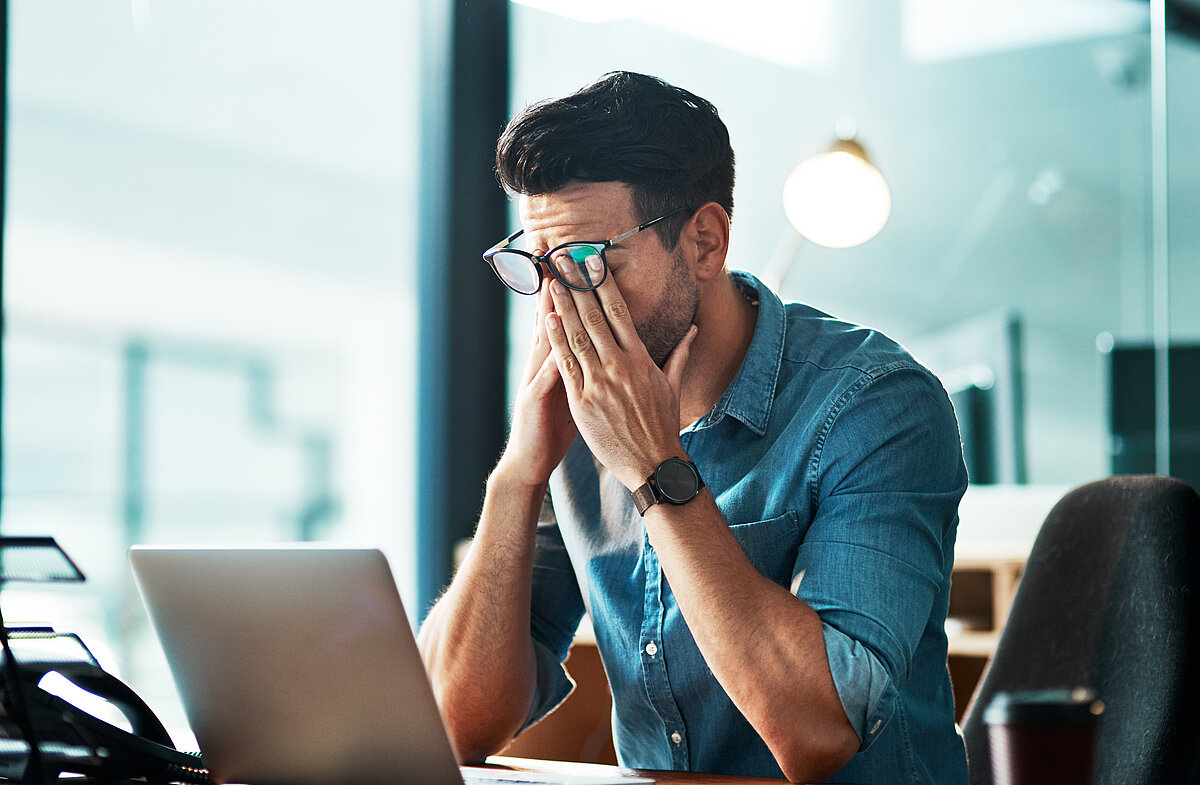 Mann verzweifelt am Arbeitsplatz