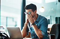 Mann verzweifelt am Arbeitsplatz