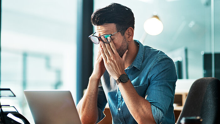 Mann verzweifelt am Arbeitsplatz