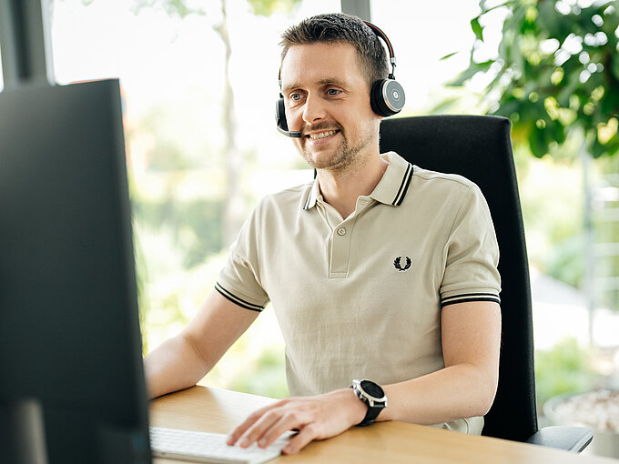 SP_Data Mitarbeiter mit Headset am Arbeitsplatz