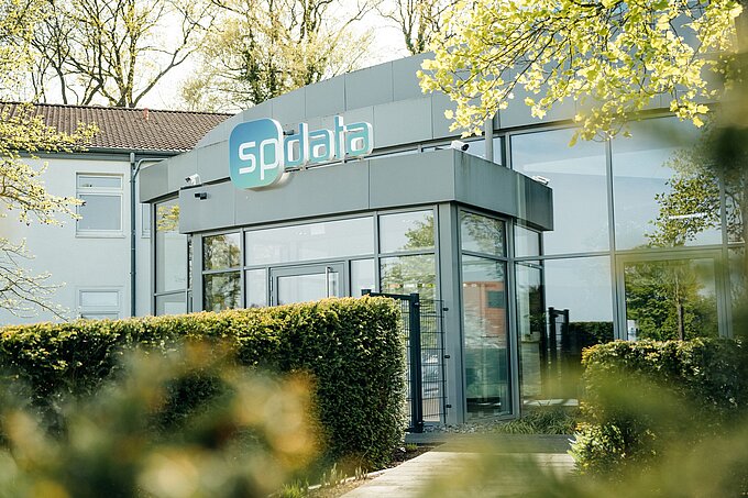 Haupteingang zum SP_Data Gebäude mit Logo über der Tür