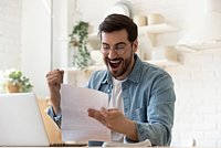Ein Arbeitnehmer hält seine Gehaltsabrechnung in der Hand und ballt dabei die Faust vor Freude