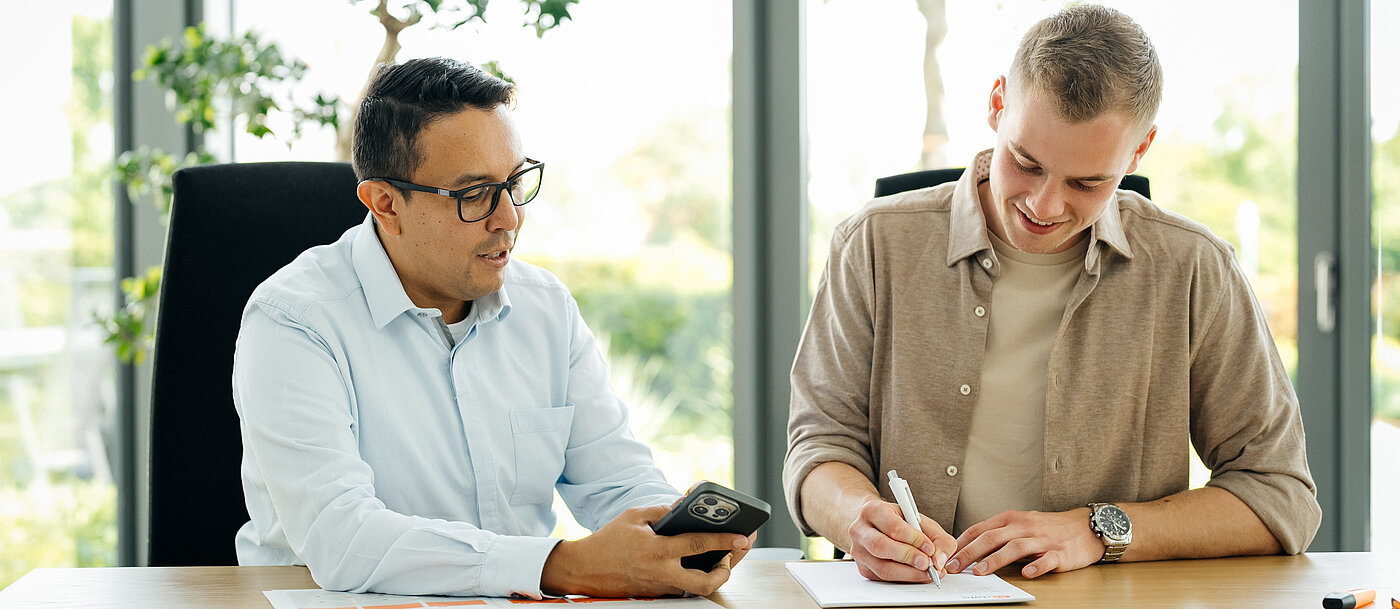 Mitarbeiter von SP_Data arbeiten zusammen am Schreibtisch