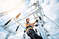 Ein Mann in Sichheits-Arbeitskleidung steht auf einem Baugrüst