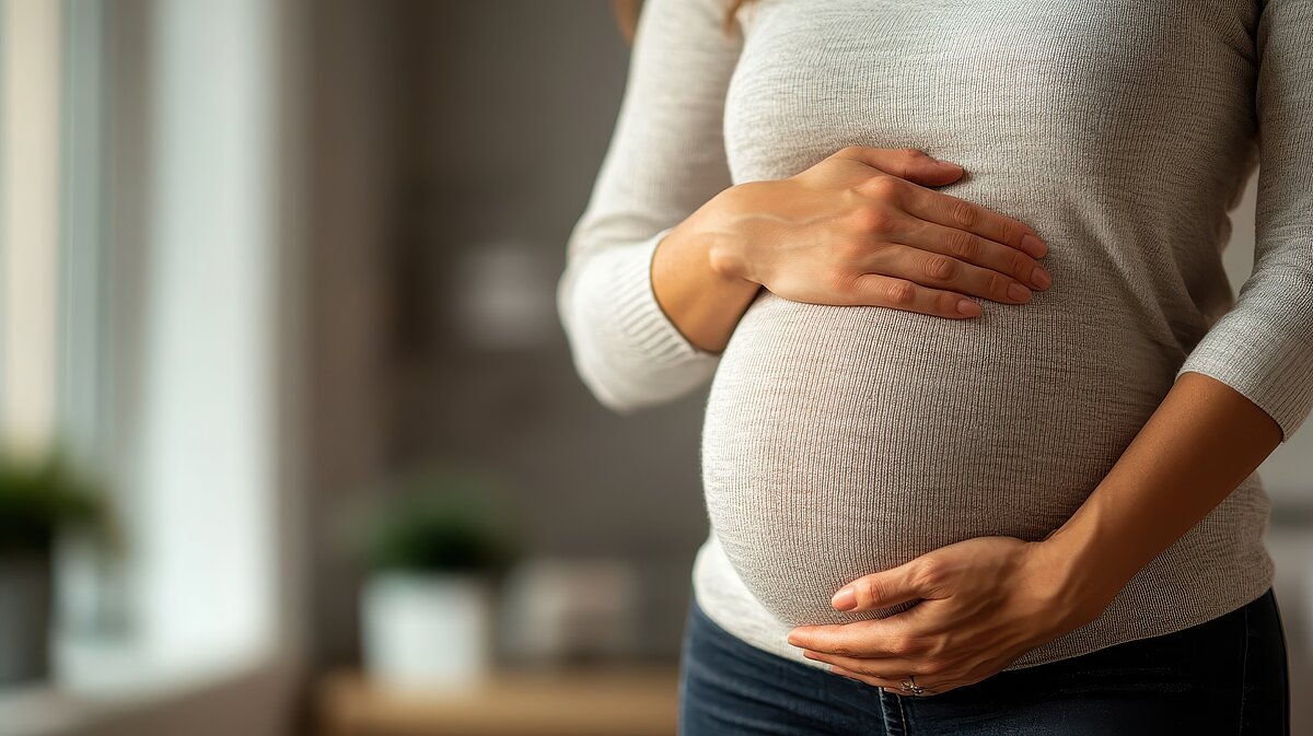 Schwangere Frau hält schützend ihre Hände auf ihren Babybauch – Symbol für Mutterschutz und Schwangerschaft