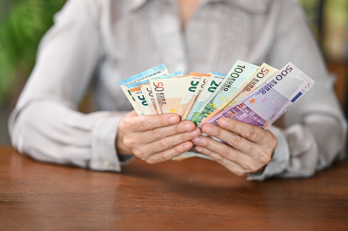 Person hält Geldscheine in der Hand