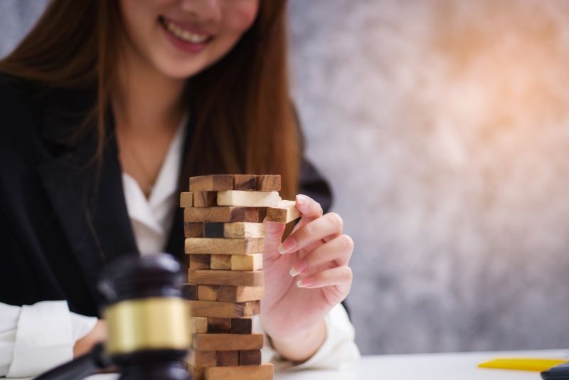 Frau spielt Jenga und lächelt