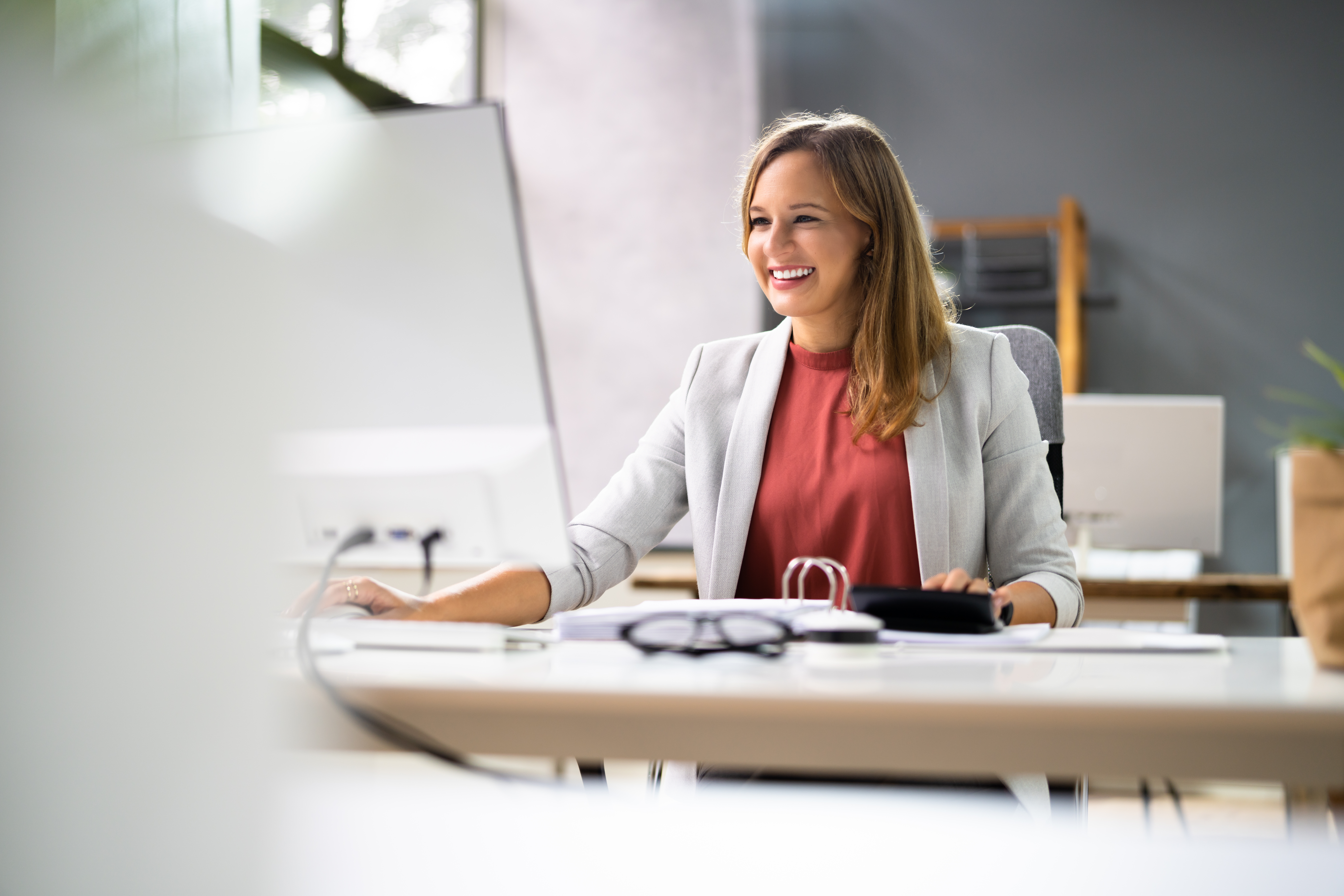 Frau arbeitet am PC und lächelt